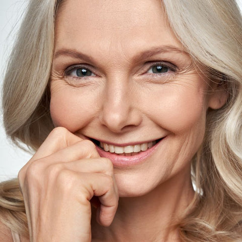 Smilende moden kvinne med sunn hud, som representerer fordelene med kollagenprotein for anti-aldring og hudhelse.
