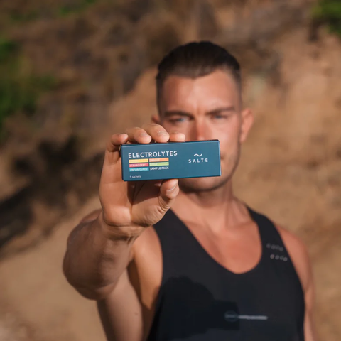 SALTE Elektrolytter prøvepakke holdt av en person, viser fem smaker: Nøytral, Eple, Appelsin, Sitron, Jordbær.